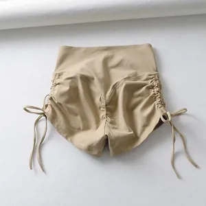 Detalle trasero de los pantalones cortos de yoga caqui de talle alto con cordón