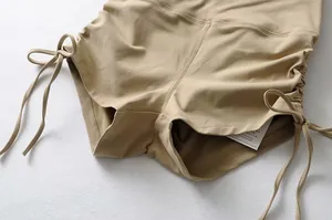 Primer plano de pantalones cortos de yoga caqui de talle alto con cordones ajustables.