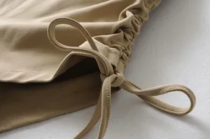 Primer plano del detalle del cordón y fruncido lateral en pantalones de yoga