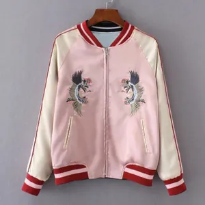 Frontdetail der rosa Satin-Bomberjacke mit aufwendigen Kranich-Stickereimotiven