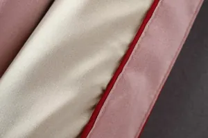 Makrodetail aus hochwertigem Satinstoff und roter Paspel an der Sukajan-Wendejacke