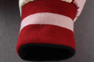 Nahaufnahme des rot-pink gestreiften Rippstrickbündchens an einer Retro-Bomberjacke