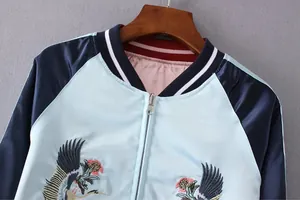 Detailansicht der aufwendigen Kranich-Stickerei auf einer blauen Satin-Souvenirjacke.