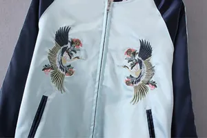 Detailansicht der hochwertigen Kranichstickerei auf einer hellblauen Sukajan-Bomberjacke
