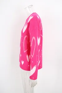 Detailed side view of vibrant pink crewneck sweater with oversized heart knit patterns