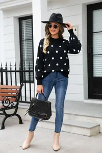 Full body shot of a woman wearing a stylish black oversized polka dot pullover sweater