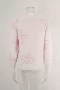 Back view detail of white knit sweater featuring delicate pink flower outlines