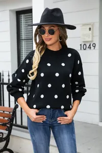 Stylish black polka dot pullover sweater worn by a model in an outdoor setting