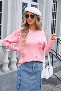 Close-up of a pink long-sleeved crewneck knit sweater with floral patterns on a model
