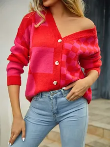 Close-up of a women's red and pink checkered patchwork knitted cardigan with white buttons