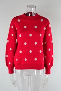 Detail view of a vibrant red knit sweater featuring a classic white polka dot pattern