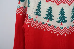 Gros plan sur la texture en tricot d'un pull de Noël rouge et blanc avec des sapins