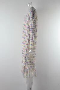 Side view of colorful knitted long cardigan with decorative fringe hem on mannequin
