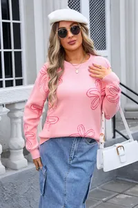 Detailed view of pink long-sleeved sweater featuring floral knit patterns and round neck