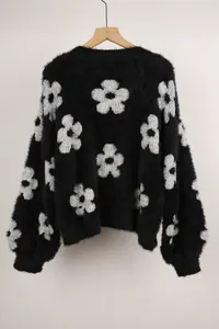 Vista posterior detallada de un cárdigan de punto negro con motivos de flores blancas