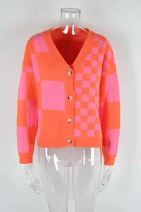 Close-up detail of women's pink and orange checkerboard knit cardigan with V-neck