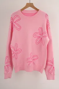 Close-up detail of the knit texture and pink floral pattern on the sweater
