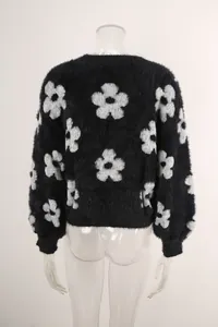 Vista trasera de un jersey de punto negro con motivos de flores blancas grandes