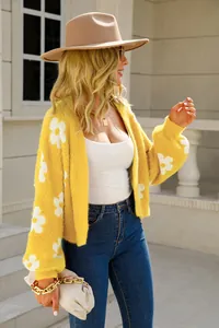Cárdigan de punto peludo amarillo con grandes motivos de flores blancas en entorno exterior