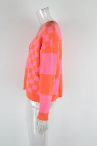 Side view of women's pink and orange checkered oversized knit sweater on clear mannequin
