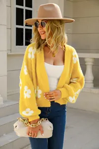 Detalle de cárdigan de punto amarillo con flores mostrando la textura suave y esponjosa