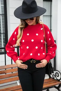 Detailed shot of the stylish red knitted sweater featuring white polka dots and round neck