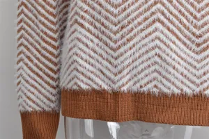 Close-up of brown and white chevron knit sweater showing fuzzy texture and ribbed hem.