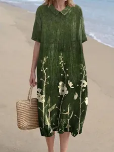 Gedetailleerd overzicht van een groene maxi-jurk met bloemen en Peter Pan-kraag.