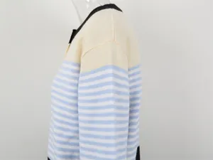 Gros plan sur la texture tricotée à rayures bleues et blanches d'un cardigan.