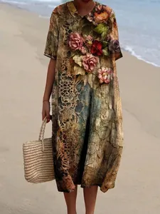 Detailweergave van een vintage maxi-jurk met bloemenprint en Peter Pan-kraag op het strand