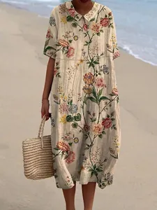 Vintage lange jurk met bloemenprint en poppenkraag op een zonnige strandachtergrond