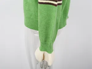 Gros plan sur la manche d'un cardigan vert avec poignet évasé blanc et rayures contrastées