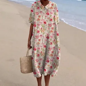 Casual midi-jurk met bloemenprint, Peter Pan-kraag en korte mouwen in een strandsetting.