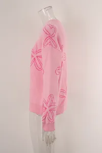 Side view of pink long-sleeve knit sweater featuring artistic line-drawn flower patterns