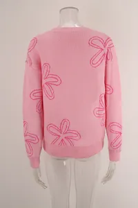 Detailed back view of a pink oversized knit sweater featuring magenta flower patterns