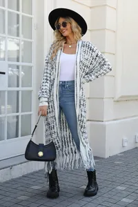 Fashionable long plaid knit cardigan with fringe hem shown in an outdoor street scene