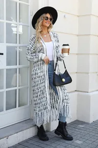 Outdoor fashion shot of a chic long knit cardigan featuring fringe hem and grid pattern