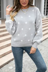 Detailed macro view of a grey crewneck sweater featuring charming white polka dots