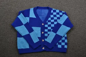 Detailed view of a blue checkered V-neck cardigan with contrasting patterns and buttons