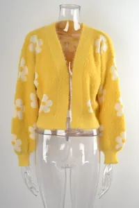 Vista frontal detallada de un cárdigan corto de punto amarillo con patrones de flores blancas