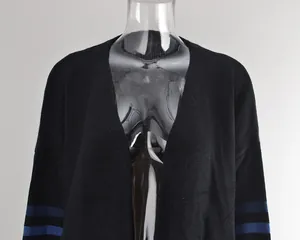 Détail d'un cardigan en maille noire avec rayures bleues sur les manches sur mannequin