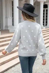 Back view of a chic grey polka dot knit pullover sweater styled with a black wide brim hat
