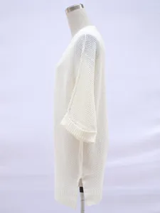 Seitenansicht der cremefarbenen Strickjacke in Übergröße mit Seitenschlitz.