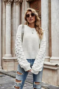 Elegant white knitted sweater with unique bubble sleeve details shown on a fashion model