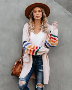 Détail d'un cardigan en maille oversize avec rayures arc-en-ciel sur les manches.