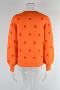 Back view of casual orange knit sweater with red polka dot pattern on clear mannequin