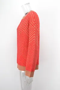 Side profile of women's vibrant orange and tan chevron knit sweater with fuzzy texture