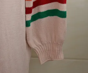 Gros plan d'une manche de pull en maille avec poignets rayés colorés