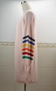 Vue latérale d'un pull en maille rose avec des rayures arc-en-ciel sur la manche.