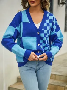 Detailed close-up of the blue checkered oversized knit cardigan with button closure